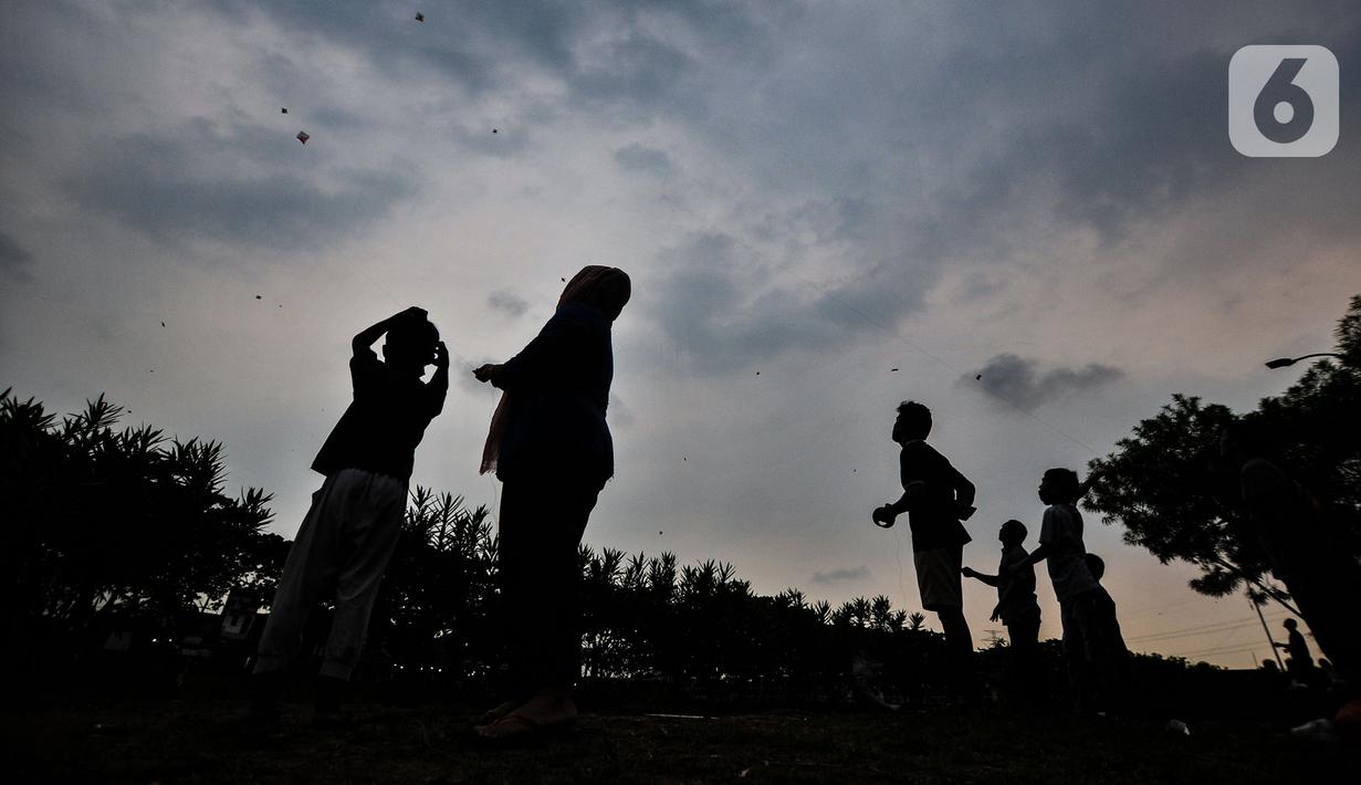 Warga bermain layang-layang di pinggir Kanal Banjir Timur (KBT), Duren Sawit, Jakarta, Senin (19/4/2021). KBT menjadi lokasi favorit warga untuk mengisi waktu menunggu buka puasa atau ngabuburit, salah satunya dengan bermain layang-layang bersama keluarga. (merdeka.com/Iqbal S Nugroho)