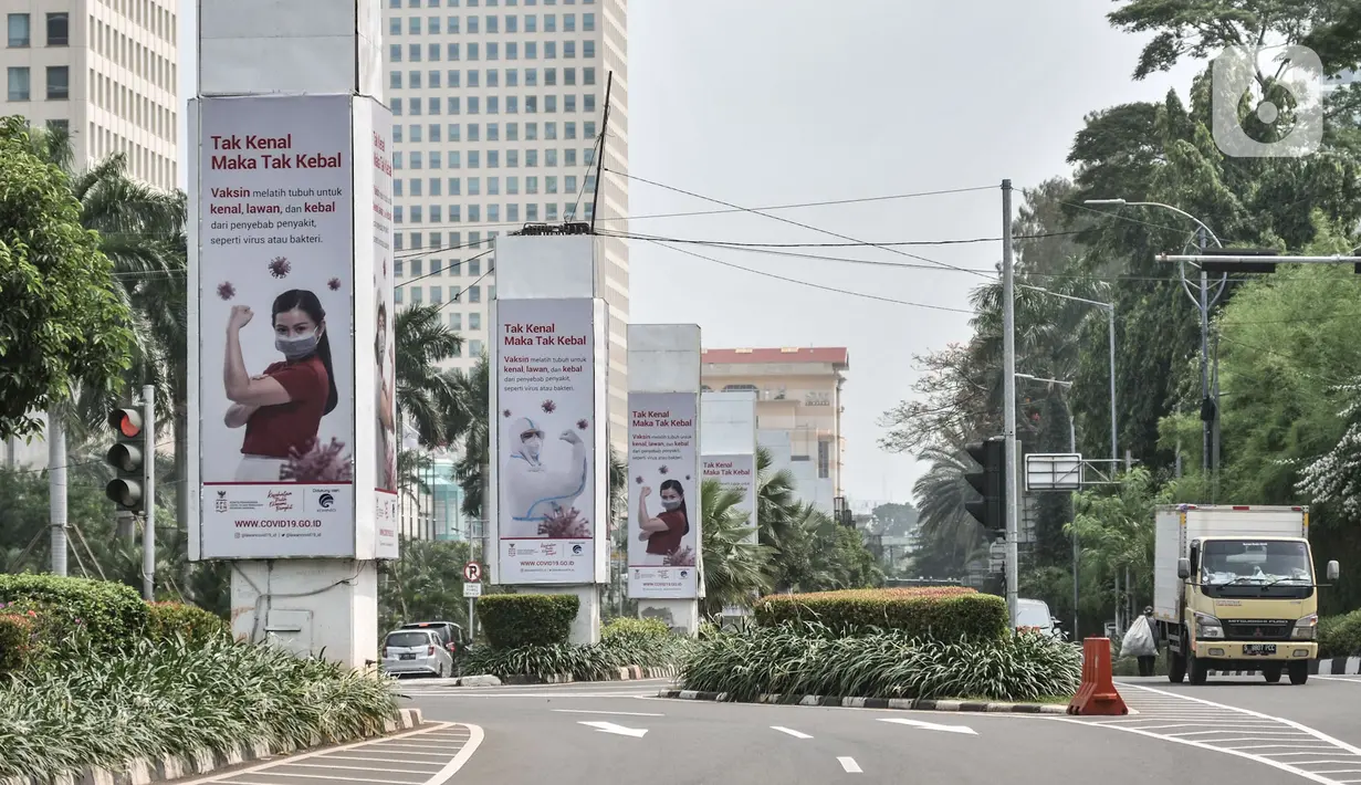 Kendaraan melintas di dekat papan reklame sosialisasi vaksin Covid-19 di tiang pancang proyek monorel, Senayan, Jakarta, Selasa (17/11/2020). Tiang pancang monorel yang terbengkalai selama 16 tahun itu dimanfaatkan oleh sebagai papan reklame sosialisasi vaksin Covid-19. (merdeka.com/Iqbal S Nugroho)