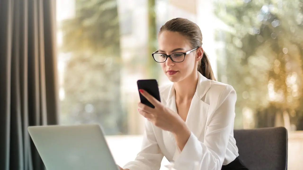 Wanita membuka HP dan laptop (Pexels)
