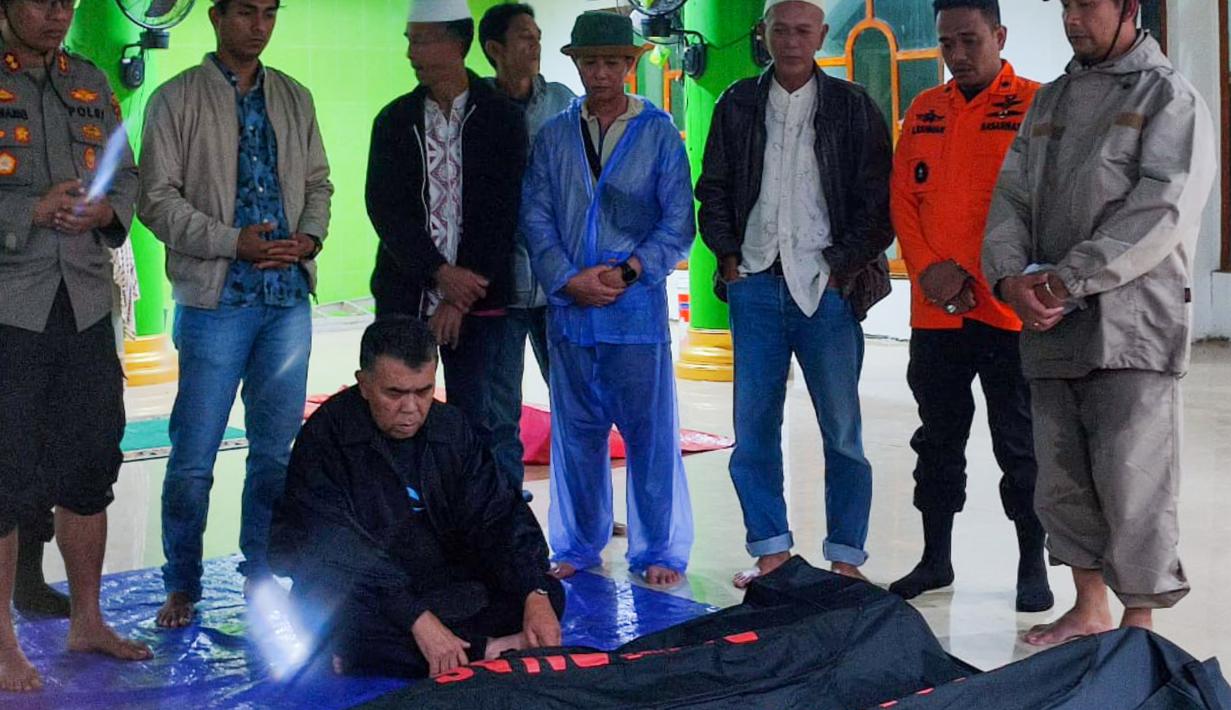 Foto selebaran yang diambil dan dirilis pada 7 Maret 2023 oleh kantor Kementerian Komunikasi dan Informatika Natuna ini menunjukkan para pejabat berdoa untuk para korban tanah longsor di Natuna, Kepulauan Riau (Kepri). Evakuasi terus dilakukan dengan kewaspadaan tinggi karena tanah masih labil dan masih terjadi longsor susulan. (HO / Natuna ministry of communication / AFP)