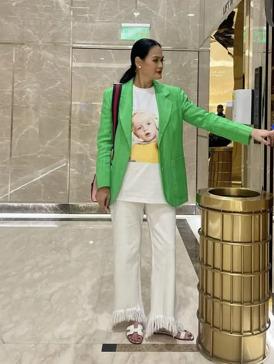 <p>Ia juga tampil bright dengan blazer hijau neon dipadukan inner tshirt putih bergambar, yang serasi dengan celana ruffle dan sandal Hermesnya.&nbsp;@donnaharunofficial</p>