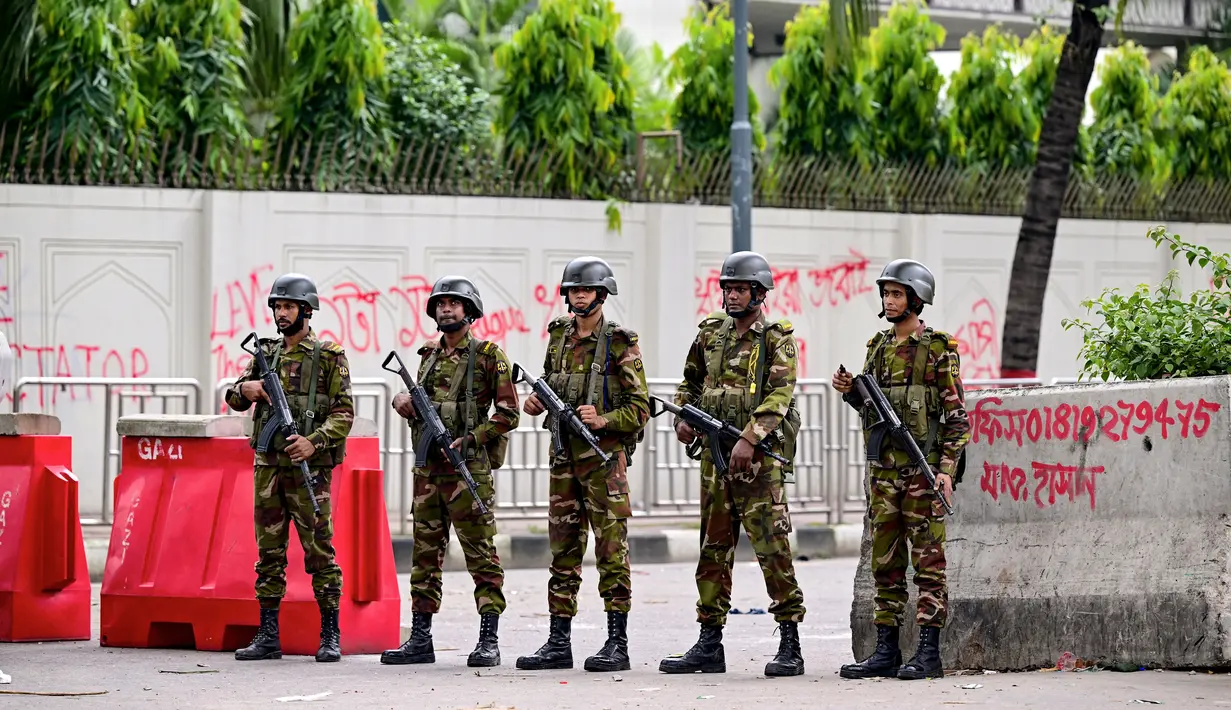 Personel militer Bangladesh berjaga selama jam malam menyusul bentrokan antara polisi dan aktivis Gerakan Mahasiswa Anti-Diskriminasi di tengah protes anti-pemerintah di daerah Shahbag, Dhaka, Senin (5/8/2024). (Munir UZ ZAMAN / AFP)