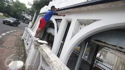Pekerja melakukan pengecatan pintu air Istiqlal, Jakarta Pusat, Senin (14/11). Pengecatan dilakukan untuk menjaga pintu air yang merupakan salah satu cagar budaya tersebut agar tetap bersih dan terawat. (Liputan6.com/Immanuel Antonius)