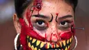 Seorang wanita berpartisipasi dalam Zombie Walk di Mexico City, Minggu (11/11). Dalam acara tahunan itu ratusan orang dengan penampilan yang seram serta mengenakan pakaian compang-camping berkumpul di pusat bersejarah ibu kota Meksiko. (AP/Claudio Cruz)