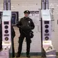 Petugas kepolisian New York berjaga di pintu masuk stasiun kereta bawah tanah Times Square saat jam sibuk malam di New York City, Senin (11/12). Sebelumnya ledakan bom terjadi di terminal bawah tanah kawasan Manhattan. (Drew Angerer/Getty Images/AFP)