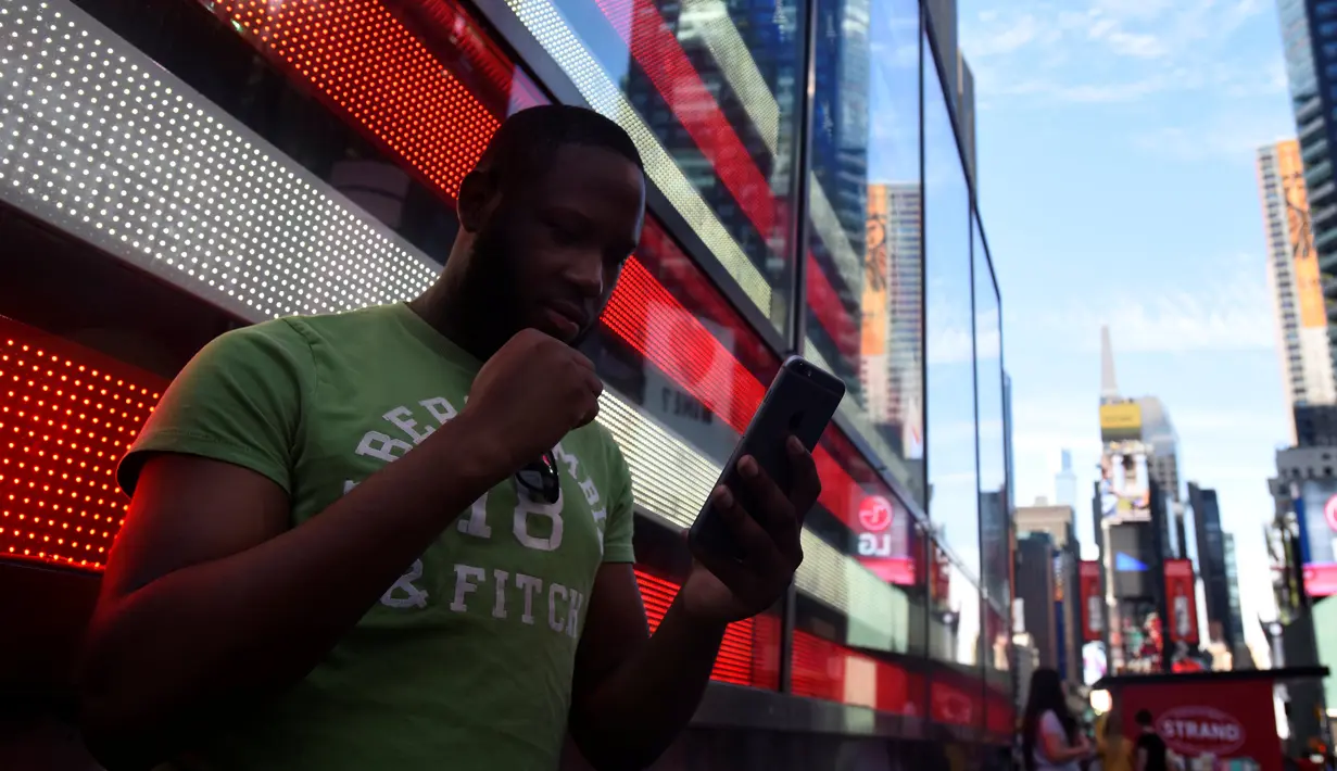Theodore Belizaire mengepalkan tangan saat bermain augmented reality Pokemon Go di Times Square, New York City, Amerika Serikat, 11 Juli 2016. Demam Pokemon Go mewabah di kalangan para gamers ponsel cerdas. (REUTERS/Mark Kauzlarich)