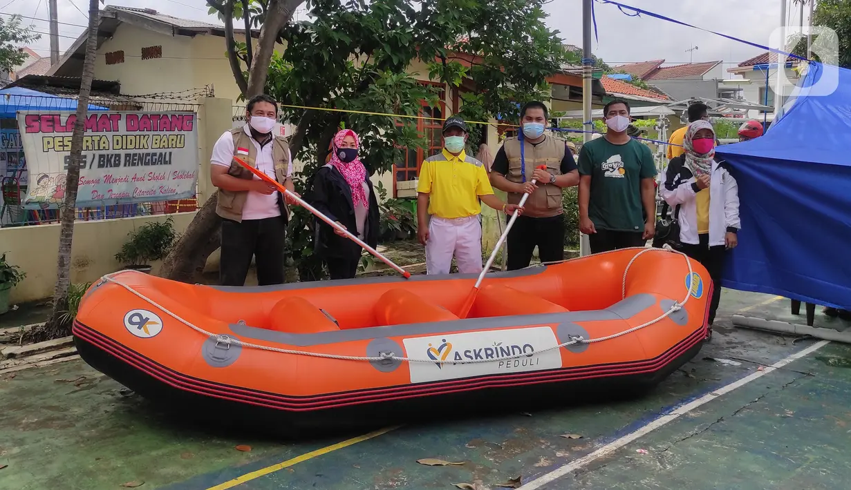 Karyawan PT. Askrindo secara simbolis memberikan bantuan perahu karet kepada warga korban banjir di Bekasi, Senin (22/02/2021). Bantuan perahu karet untuk proses evakuasi korban banjir diberikan di Pondok Timur Mas, Bekasi Selatan dan Perumnas III, Kota Bekasi. (Liputan6.com/Pool)