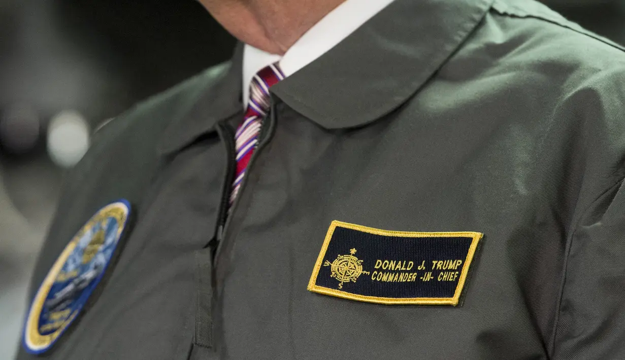 Presiden AS, Donald Trump mengenakan jaket panglima tertinggi Navy Seal saat mengunjungi kapal induk Gerald R. Ford di Newport News, Virginia (2/3). (AFP Photo / Saul Loeb)