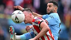 Pemain Manchester City, Riyad Mahrez (kanan) berebut bola dengan pemain Sheffield United, Jack Robinson pada laga semifinal Piala FA 2022/2023 di Stadion Wembley, London, Minggu (23/04/2023) WIB. The Cityzens sukses meraih kemenangan melalui hattrick Mahrez. (AFP/Glyn Kirk)