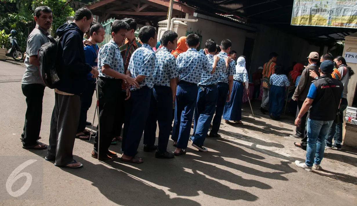 Penyandang disabilitas mengantre memasuki lokasi untuk menggunakan hak pilihya dalam Pilkada Putaran kedua di TPS 07 Kelurahan Cawang, Jakarta, Rabu (19/4). Penyandang disabilitas boleh membawa pendamping selama pencoblosan. (Liputan6.com/Gempur M. Surya)
