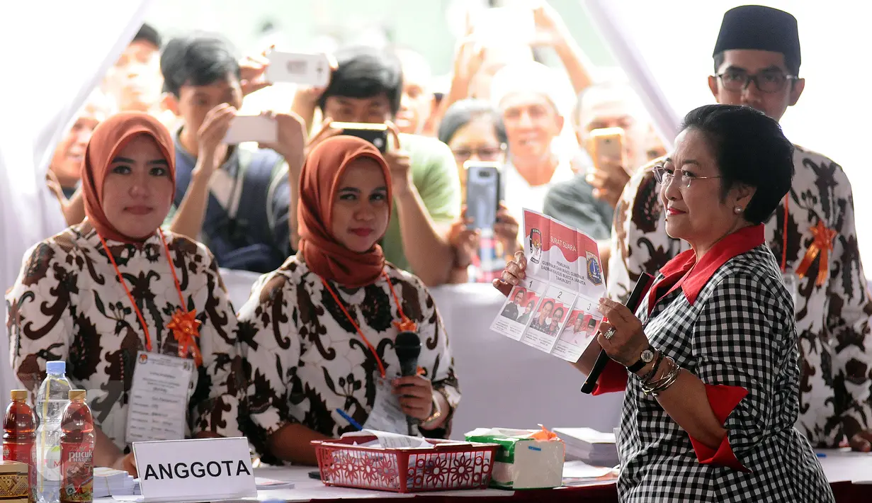 Presiden ke-5 RI yang juga Ketua Umum PDIP, Megawati Soekarnoputri menunjukkan surat suara sebelum mengikuti proses pencoblosan Pilkada DKI 2017 di TPS 027 Kebagusan, Jakarta Selatan, Rabu (15/2). (Liputan6.com/Helmi Fithriansyah)