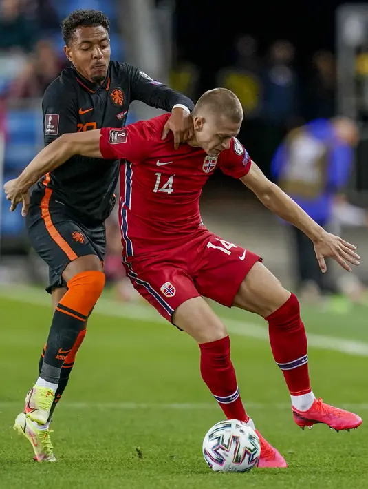 Pemain Norwegia Julian Ryerson (kanan) berebut bola dengan pemain Belanda Donyell Malen pada pertandingan kualifikasi Piala Dunia 2022 di Stadion Ullevaal, Oslo, Norwegia, Rabu (1/9/2021). Pertandingan berakhir dengan skor 1-1. (Stian Lysberg Solum/NTB via AP)