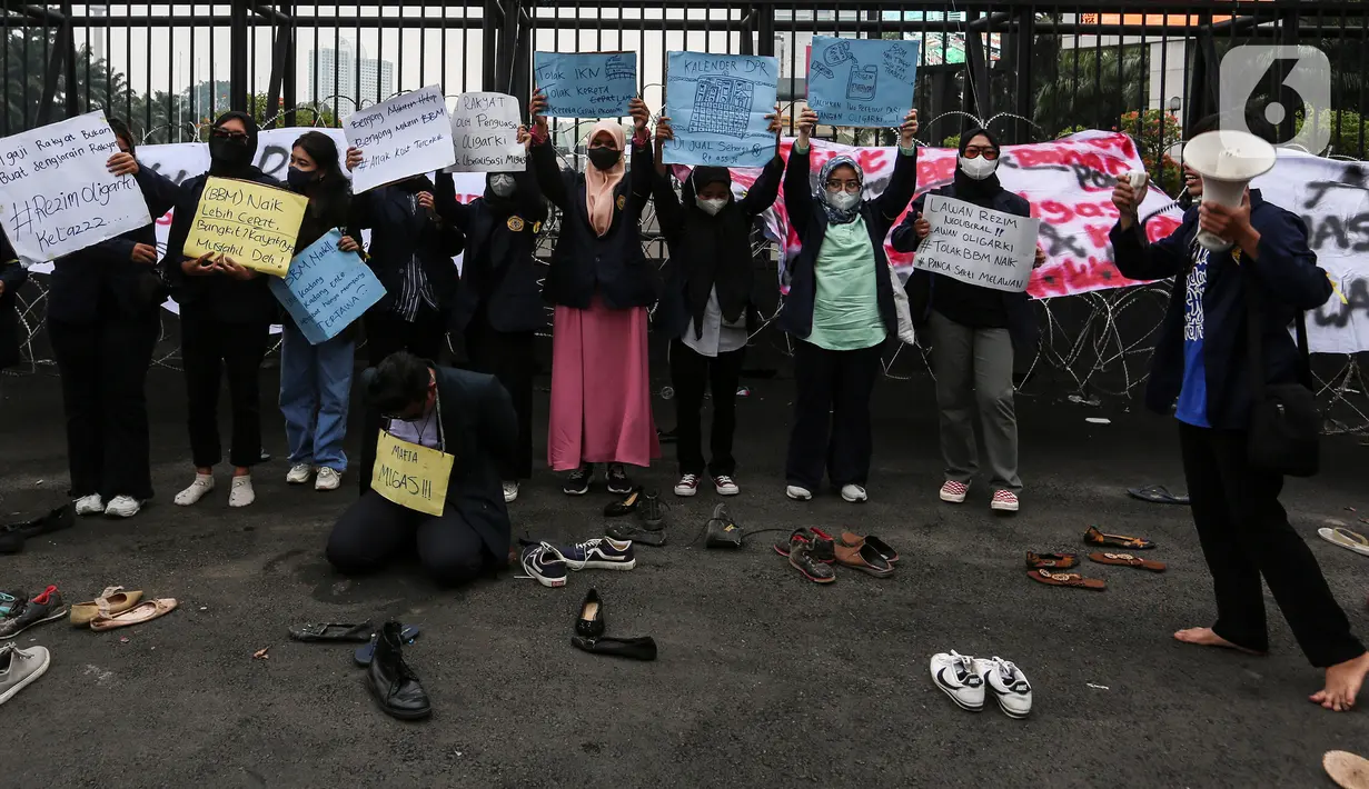 Mahasiswa melakukan aksi teatrikal sambil membawa poster tuntutan di depan Gedung DPR/MPR RI, Jakarta Pusat, Jumat (9/9/2022). Demo tersebut untuk menolak kebijakan pemerintah menaikkan harga BBM. (Liputan6.com/Johan Tallo)
