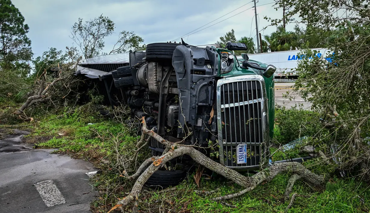 Rubuhnya sejumlah pohon dan tiang listrik serta terbaliknya beberapa truk menjadi bukti kekuatan angin puting beliung. (GIORGIO VIERA/AFP)