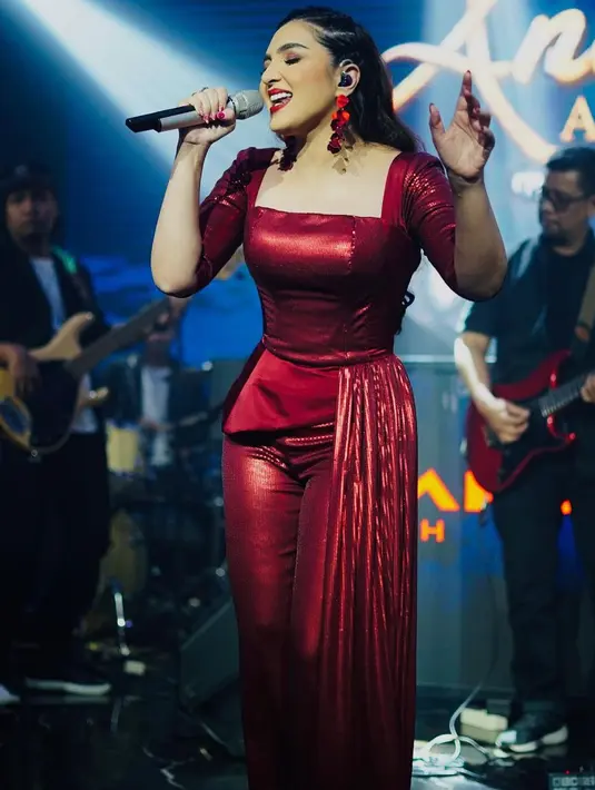 Gaya manggung yang chic dari Ashanty. Ia mengenakan jumpsuit merah yang bold. [Foto: Instagram/ashanty_ash]