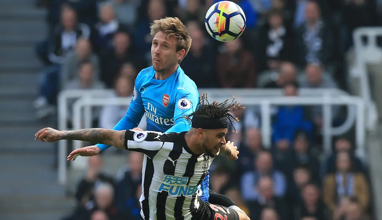 Pemain Arsenal, Nacho Monreal (kiri) melakukan duel dengan pemain Newcastle United, DeAndre Yedlin pada lanjutan Premier League di St James' Park, Newcastle, (15/4/2018). Newcastle menang 2-1. (AFP/ Lindsey Parnaby)