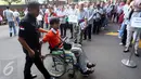 Seorang penumpang disabilitas pada acara gelar mudik bersama Bank Syariah Mandiri (BSM) di Jakarta, Sabtu (2/7). Sebanyak 1200 pemudik diberangkatkan dengan 25 bus dan satu unit mobil akses untuk disabilitas (14 Orang). (Liputan6.com/Faizal Fanani)