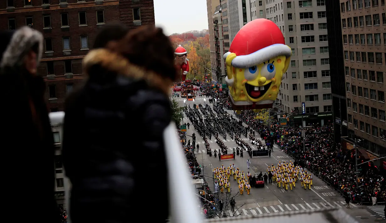 Tokoh animasi kartun Sponge Bob Squarepants melayang di atas jalanan Manhattan di New York selama parade tahunan Macy's Thanksgiving Day ke-90, Kamis (24/11). Biasanya acara ini dimulai pukul 09.00 pagi pada Hari Pengucapan Syukur. (REUTERS/Saul Martinez)