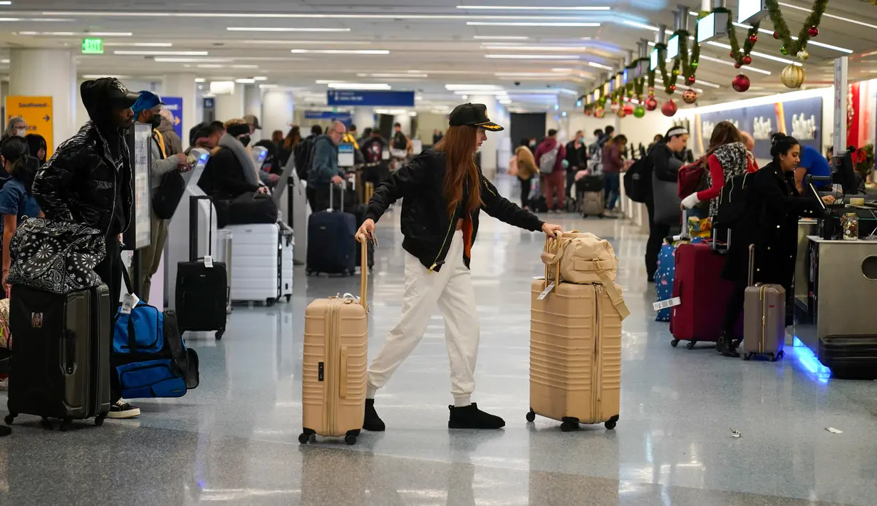 Seorang wanita berjalan ke konter tiket Southwest di Bandara Internasional Los Angeles, Los Angeles, Amerika Serikat, 19 Desember 2022. Liburan Natal dan Tahun Baru bagi sebagian warga Amerika Serikat dan Eropa tahun ini menghadirkan kekhawatiran karena tekanan ekonomi. (AP Photo/Jae C. Hong)