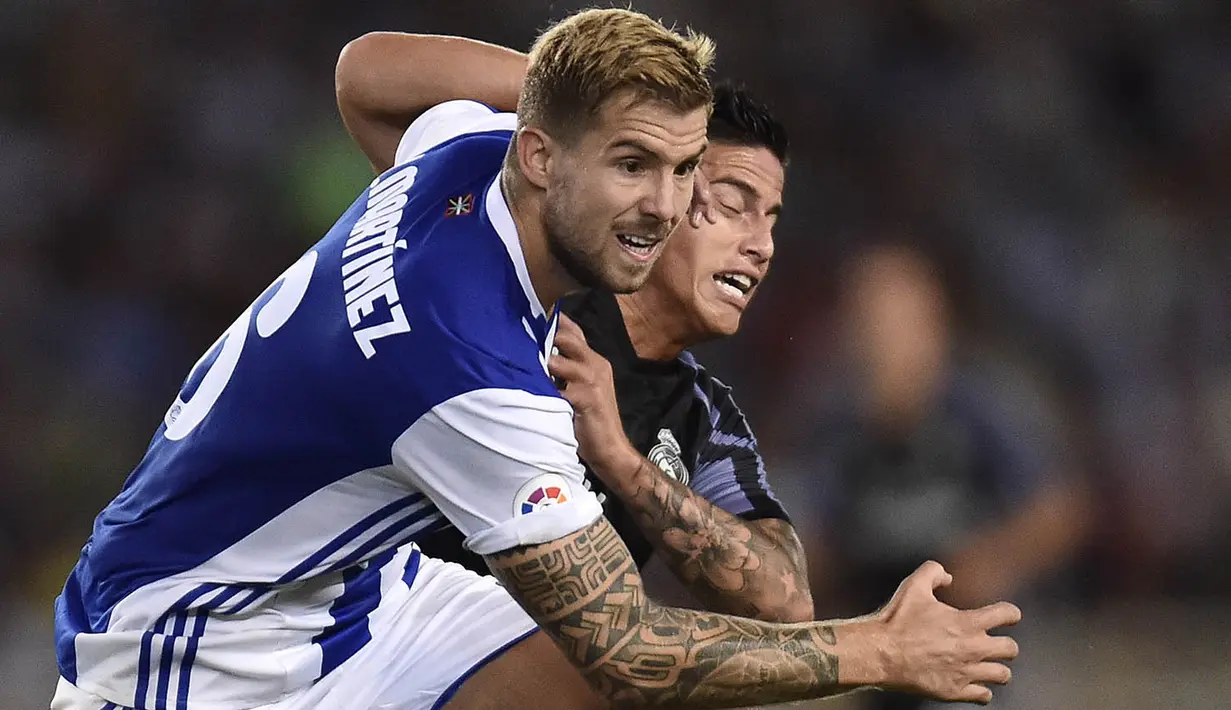 Gelandang Real Madrid, James Rodriguez, berebut bola dengan pemain Real Sociedad, Inigo Martinez. Wasit mengeluarkan tiga kartu kuning kepada pemain Madrid dan dua untuk Sociedad. (AP/Alvaro Barrientos)