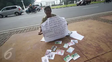 Nelly Hutabarat, guru asal Deli Serdang, Sumatera Utara, melakukan aksi diam di depan Istana Negara, Jakarta, Rabu (13/7). Nelly menuntut keadilan atas penutupan SDN 10-61-59 dan pembongkaran rumah dinasnya pada 2011 silam (Liputan6.com/Immanuel Antonius)