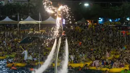 Foto pada 15 Agustus 2020 memperlihatkan orang-orang menonton pertunjukan musik sambil bermain air di sebuah taman air atau water park di Wuhan, provinsi Hubei, China. Pesta di taman air itu merupakan salah satu langkah meningkatkan ekonomi lokal yang sebelumnya lumpuh akibat Covid-19. (STR/AFP)