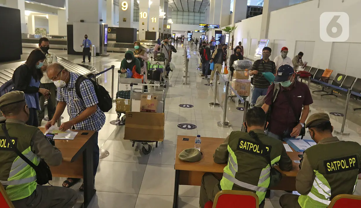 Petugas sedang mengecek SIKM di terminal 3 kedatangan domestik bandara Soekarno Hatta, Tangerang, Banten, Rabu (27/5/2020). Bandara Soetta memberlakukan Tiga checkpoint di terminal kedatangan salah satunya pemeriksaan SIKM dan doukumen kesehatan setiap penumpang. (Liputan6.com/Herman Zakharia)