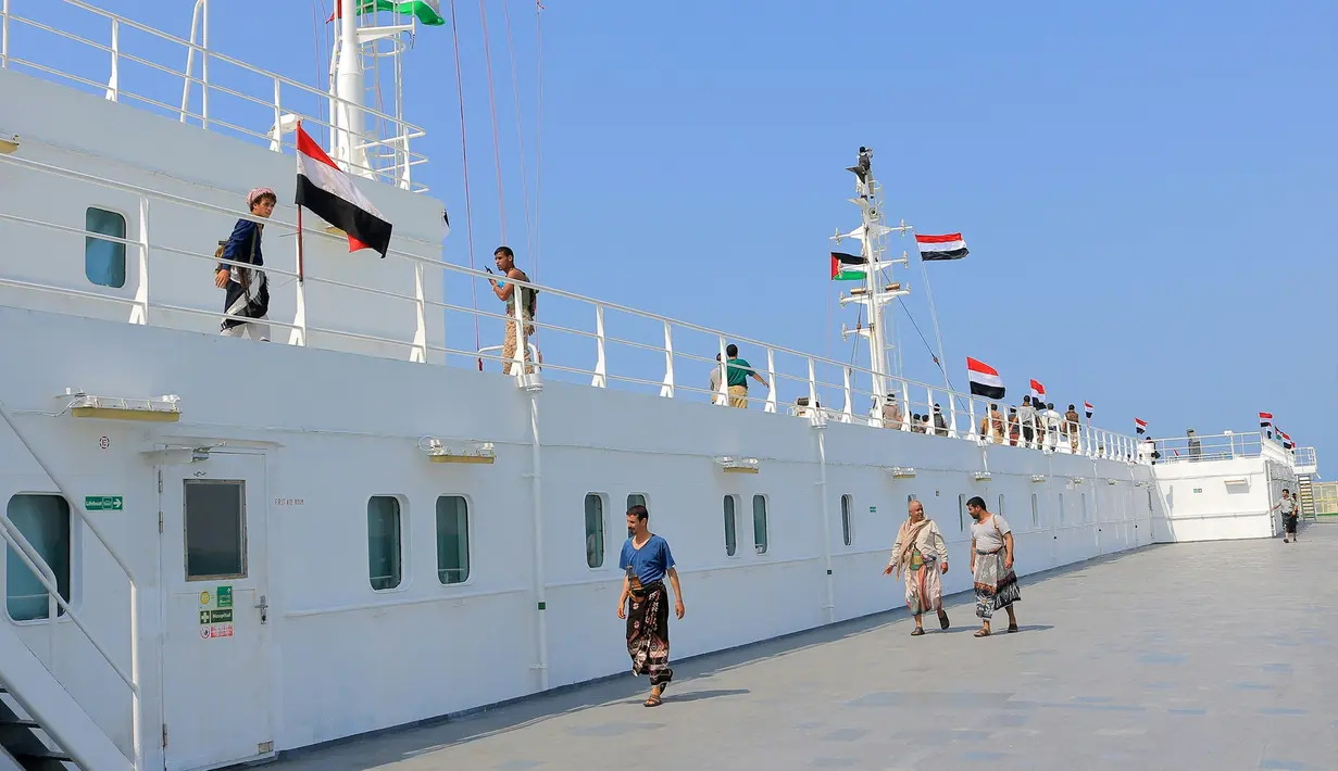 Sebuah gambar yang diambil selama tur terorganisir oleh kelompok Houthi Yaman (di atas kapal) pada tanggal 22 November 2023 menunjukkan kapal kargo Galaxy Leader, yang disita oleh Houthi dua hari sebelumnya, berlabuh di sebuah pelabuhan di Laut Merah,m Provinsi Hodeida, Yaman, dengan bendera Palestina dan Yaman dipasang di atasnya. (AFP)