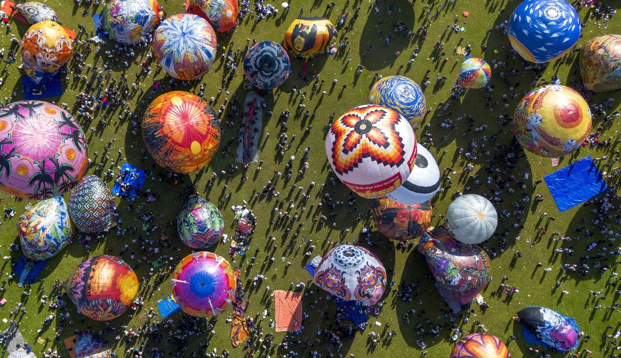 Festival tahunan ini menjadi perayaan budaya untuk memperingati akhir Ramadan dan merayakan Hari Raya Idul Fitri 1447 Hijriah. Tampak dalam foto, pemandangan udara menunjukkan balon udara yang dihiasi motif tradisional sebelum diluncurkan selama festival tahunan yang diadakan untuk merayakan Hari Raya Idul Fitri, di desa Semayu, Wonosobo, Jawa Tengah pada Senin 23 Maret 2026. (DEVI RAHMAN/AFP)