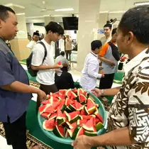Jemaah masjid Al Jihad makan semangka usai salat Jumat. (Liputan6.com/Aslam Mahfuz)