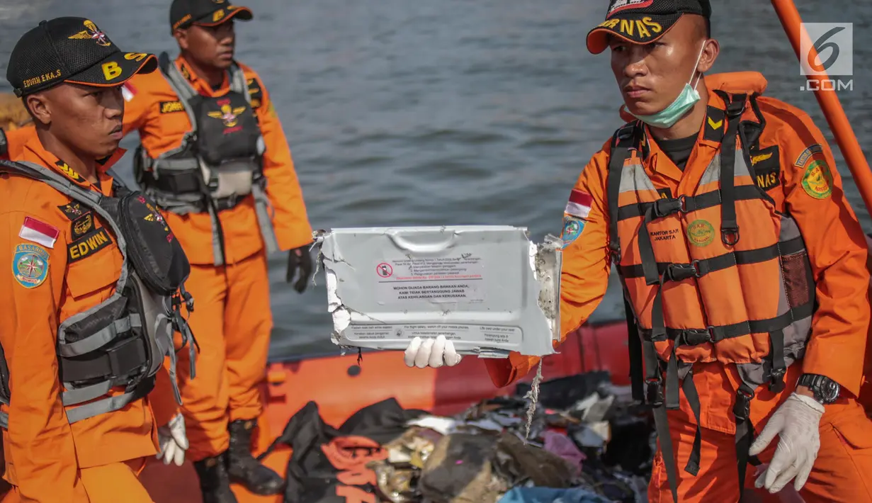 Petugas Basarnas menunjukkan serpihan pesawat Lion Air JT 610 di Posko Evakuasi, Tanjung Priok, Jakarta, Senin (29/10). Lion Air JT 610 hilang kontak usai lepas landas dari Bandara Soetta saat menuju Pangkalpinang. (Liputan6.com/Faizal Fanani)