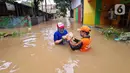 Petugas PPSU memberi bantuan nasi bungkus kepada warga yang bertahan saat banjir di kawasan pemukiman Jalan Bango, Pondok Labu, Jakarta Selatan, Sabtu (20/2/2021). Banjir akibat luapan Kali Krukut yang melanda sejak semalam menyebabkan pemukiman tergenang hingga dua meter. (merdeka.com/Arie Basuki)