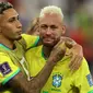 Pemain Brasil, Neymar (kanan) dihibur oleh rekannnya, Raphinha setelah tim mereka kalah dari Kroasia saat laga perempat final Piala Dunia Qatar 2022 yang berlangsung di Education City Stadium, Al-Rayyan, Jumat (09/12/2022) waktu setempat. Brasil kalah 2-4 dari Kroasia saat babak adu penalti. (AFP/Adrian Dennis)