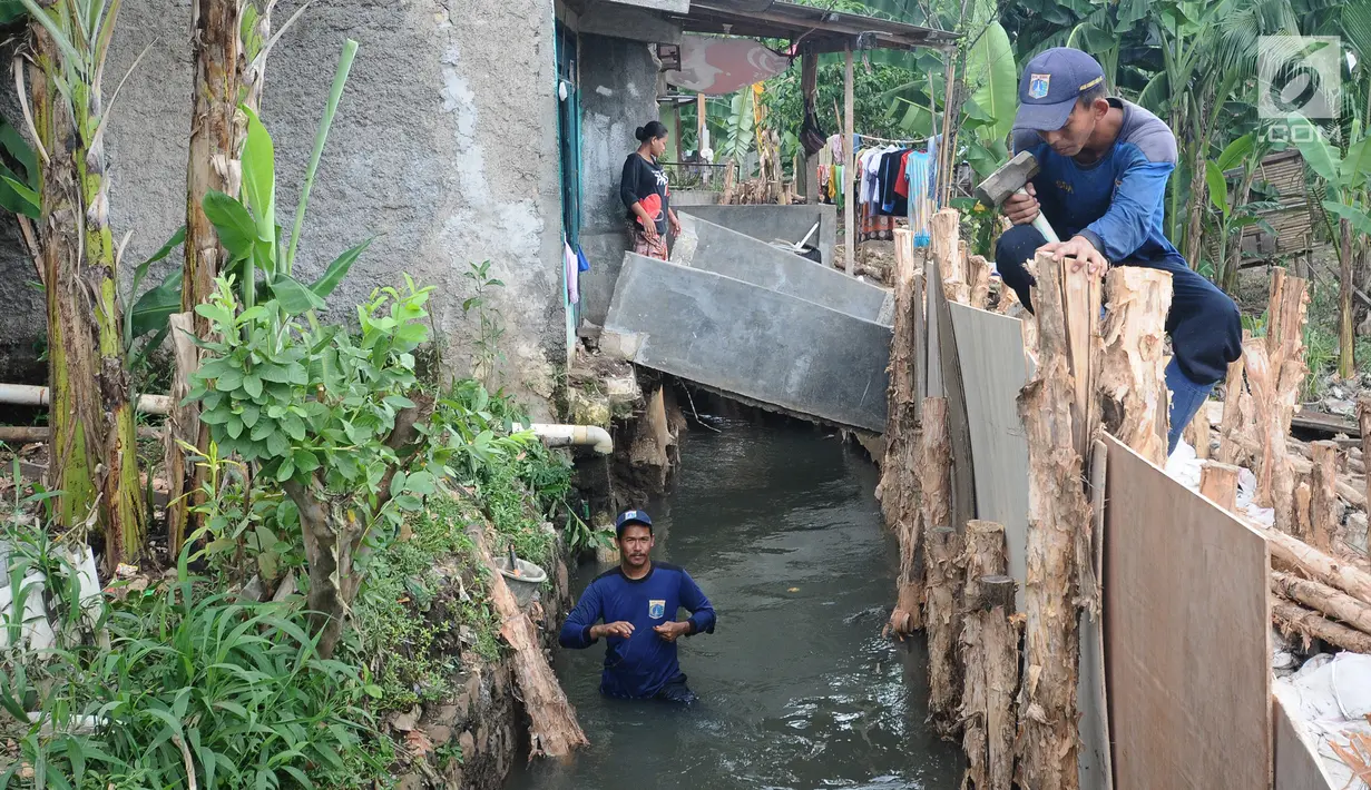 Pekerja Suku Dinas Sumber Daya Air (SDA) memperbaiki tanggul yang kembali jebol di kawasan Jati Padang, Pasar Minggu, Jakarta Selatan, Kamis (18/4). Tanggul jebol akibat derasnya air kali Pulo akibat hujan deras yang melanda kawasan Jakarta pada 16 April 2019 lalu. (Liputan6.com/Herman Zakharia)