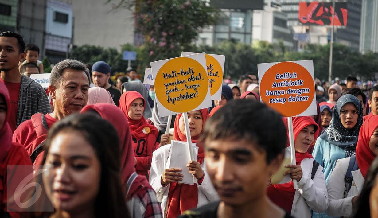 Peserta dari ISMAFARSI melakukan longmarch memperingati Hari Apoteker Sedunia di kawasan Car Free Day, Jakarta, Minggu (25/9). Mereka mengajak masyarakat cerdas menggunakan obat, termasuk DaGuSiBu. (Liputan6.com/Faizal Fanani)