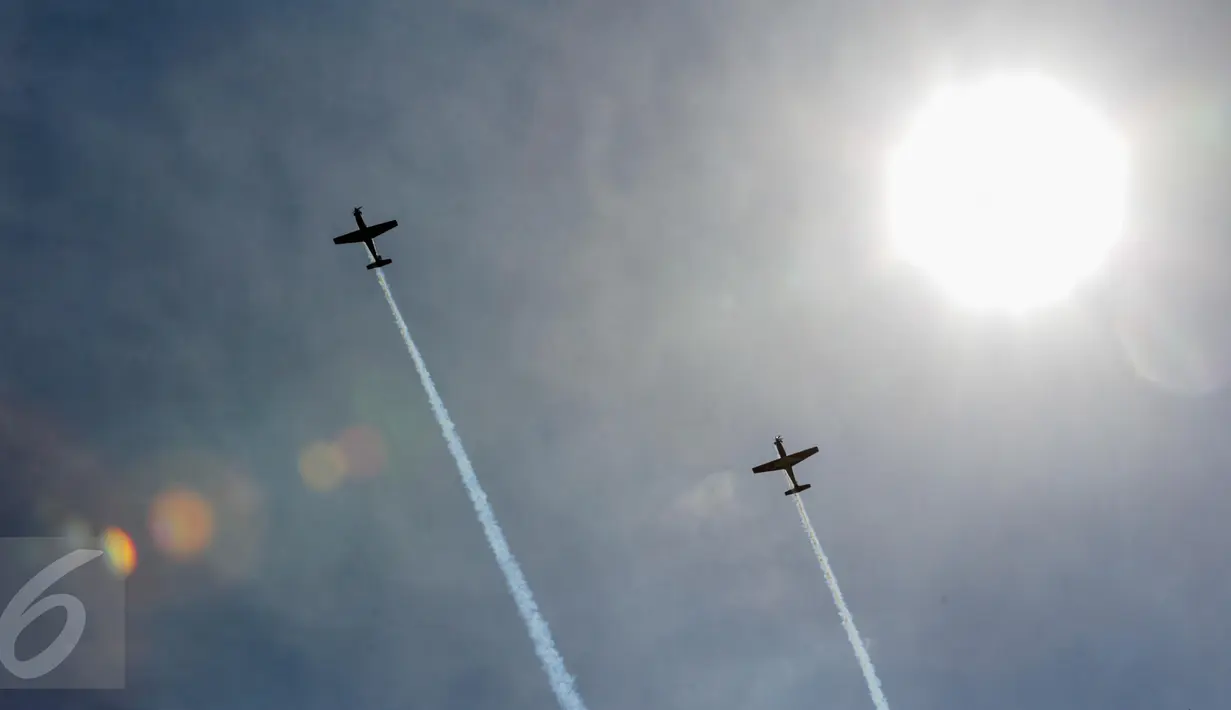 Aksi aerobatik udara Jupiter Aerobatic Team (JAT) dalam perayaan HUT TNI AU ke-71 di Bandara Halim Perdanakusuma, Jakarta, Minggu (9/4). Aksi aerobatik udara Jupiter Aerobatic Team (JAT)ini  menggunakan pesawat jenis Mongbee. (Liputan6.com/Faizal Fanani)
