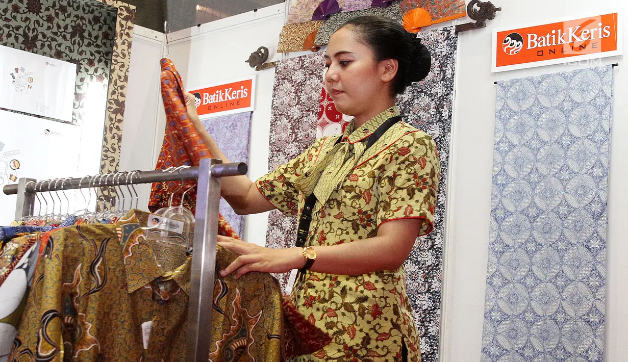 Pegawai merapikan kain batik yang dipajang pada acara Relaunching Batik Keris Online di Bekraf Habibie Festival 2017 Jakarta. Batik Keris mulai merambah ke Online hadir dengan tampilan dan fitur yang terbaru. (Liputan6.com/Pool)