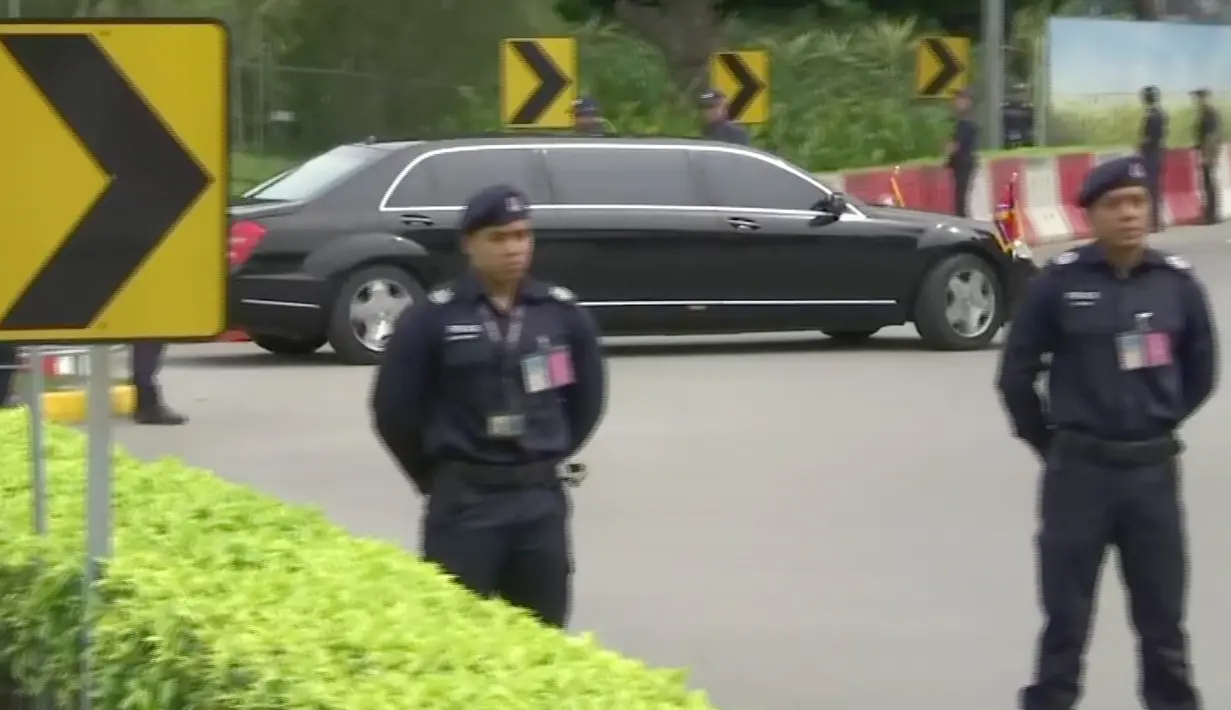 Sebuah limusin dengan bendera Korea Utara yang diyakini membawa Kim Jong-un melintasi jalanan di Singapura, Minggu (10/6). Kedatangan Kim menjelang pertemuan bersejarah dengan Presiden AS, Donald Trump pada Selasa mendatang. (AP Photo)