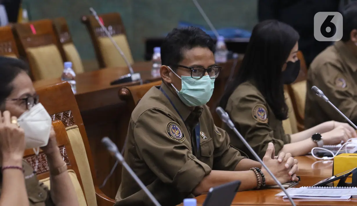 Menteri Pariwisata dan Ekonomi Kreatif Sandiaga Uno didampingi Wakil Menteri Anggela Herliani Tanoesoedibjo mengikuti Rapat Kerja dengan Komisi X di gedung DPR RI, Jakarta, Kamis (14/1/2021). (Liputan6.com/Angga Yuniar)