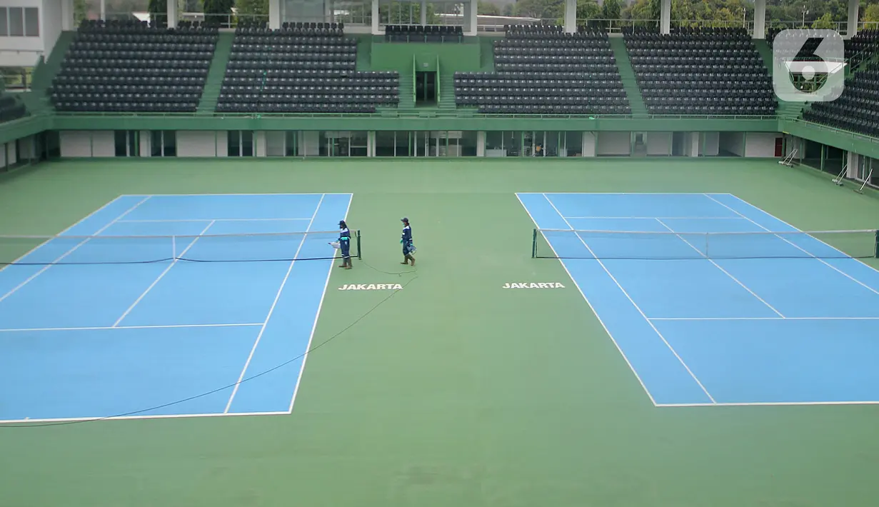 Petugas menyemprotkan cairan disinfektan pada area Lapangan Tennis Outdoor di Kompleks Olahraga GBK (Gelora Bung Karno), Senayan, Jakarta, Kamis (19/3/2020). Penyemprotan untuk mencegah penyebaran Virus Corona Covid-19 di Lingkungan Kompleks Olahraga GBK. (Liputan6.com/Herman Zakharia)