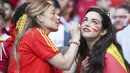 Suporter Timnas Spanyol melukis di wajah rekannya saat mendukung timnya saat melawan Italia pada laga semifinal Euro 2020 di Stadion Wembley, Rabu (7/7/2021). (Foto:AP/Laurence Griffiths,Pool)