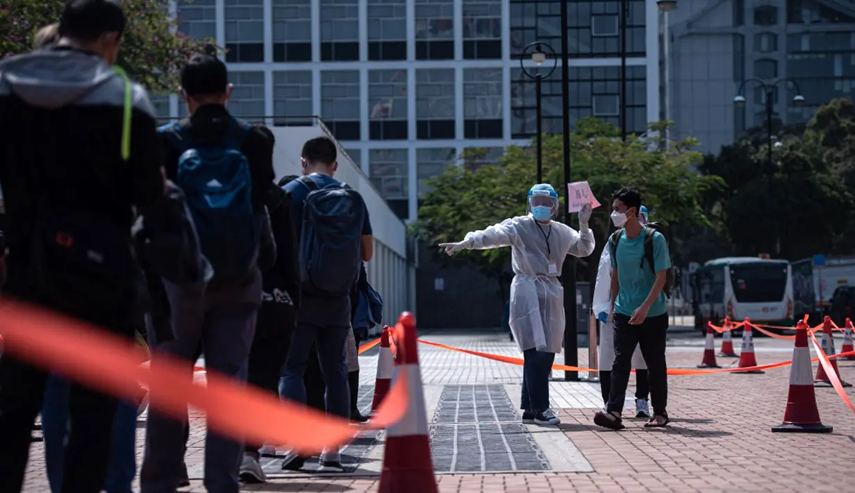 Orang-orang berdiri dalam antrean untuk pengujian virus corona COVID-19 di Hong Kong, 12 Februari 2022. Pihak berwenang bergegas untuk meningkatkan kapasitas pengujian COVID-19 menyusul rekor tertinggi infeksi baru. (Louise Delmotte/AFP)