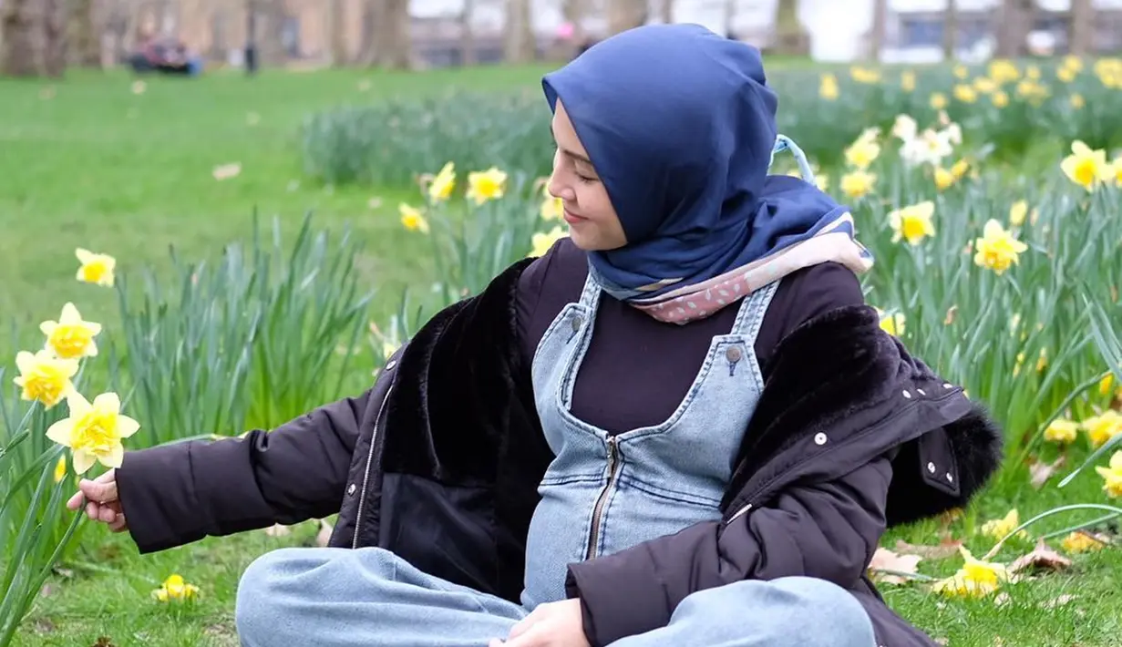 Ratna Galih tengah menikmati suasana taman dengan duduk sambil memperhatikan bunga warna kuning. Dengan memakai setelah hitam dan rompi jeans, Ratna terlihat begitu stylish. Hamil besar, tampaknya bukan penghalang Ratna untuk tampil trendi (Liputan6.com/IG/@ratnagalih)