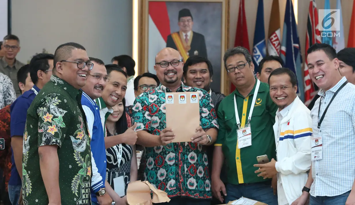Komisioner KPU, Ilham Saputra (tengah) bersama perwakilan partai politik menunjukkan amplop dokumen perolehan suara saat rapat Rekapitulasi Hasil Penghitungan Perolehan Suara Tingkat Nasional dan Penetapan Hasil Pemilu 2019, Jakarta, Minggu (5/5/2019). (Liputan6.com/Helmi Fithriansyah)