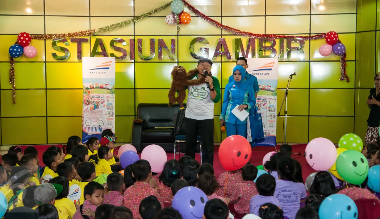 Seorang pedongeng menggunakan alat peraga saat membacakan dongeng di Stasiun Gambir, Jakarta Pusat, Senin (20/3). Memperingati Hari Dongeng Sedunia, PT KAI mengadakan hari dongeng dengan mengundang sejumlah murid PAUD. (Liputan6.com/Gempur M Surya)