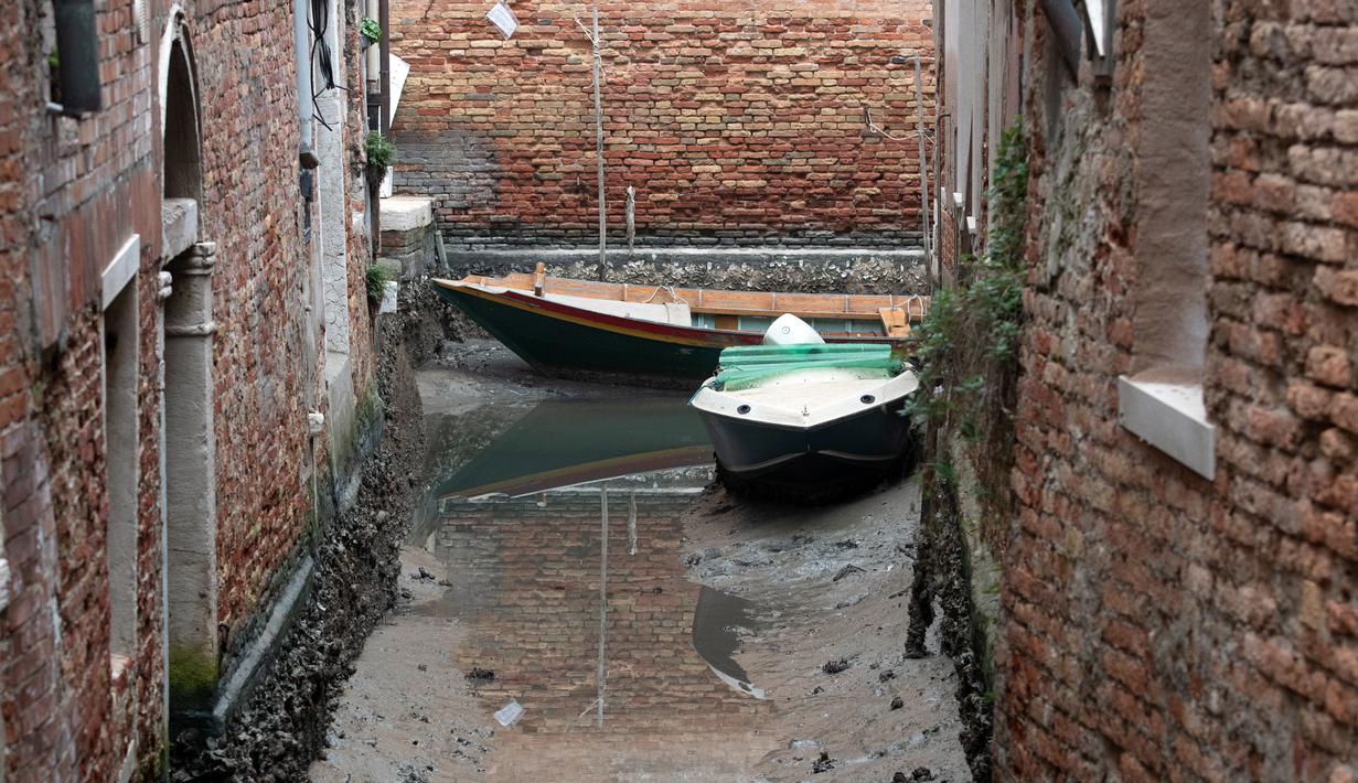 Kapal berlabuh di sepanjang kanal kering saat air surut di Venesia, Italia, 21 Februari 2023. Cuaca musim dingin yang kering selama berminggu-minggu menimbulkan kekhawatiran bahwa Italia dapat dilanda kekeringan baru. (AP Photo/Luigi Costantini)