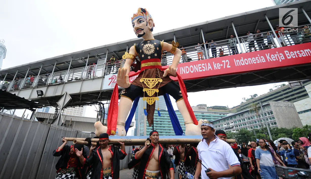 Peserta pawai perayaan Hari Batik Nasional membawa Gatotkaca saat Hari Bebas Kendaraan di kawasan Bundaran HI, Jakarta, Minggu (1/10). Parade Batik Nusantara ini perayaan Hari Batik Nasional 2 Oktober. (Liputan6.com/Helmi Fithriansyah)