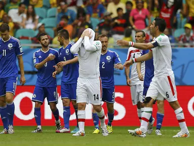 Gelandang Timnas Iran, Andranik Teymourian (tengah) menutupi wajahnya usai dikalahkan Bosnia 1-3 di penyisihan Piala Dunia Grup F, (25/6/2014). (REUTERS/Ivan Alvarado)