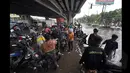 Sejumlah Pengendara Motor saat berada dibawah jembatan untuk memperbaiki motor yang mati akibat banjir, Jakarta, Senin (6/2/2015).  Hujan yang turun sejak malam hingga kini membuat sejumlah ruas jalan tergenang air. (Liputan6.com/Faizal Fanani)