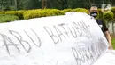 Sejumlah aktivis melakukan aksi simbolik di kawasan Patung Kuda, Jakarta, Kamis (18/3/2021). Aktivis menuntut Presiden Joko Widodo untuk mencabut Omnibus Law UU Cipta Kerja dan regulasi turunannya yang menghapus Fly Ash Bottom Ash (FABA) dari daftar limbah B3. (Liputan6.com/Faizal Fanani)